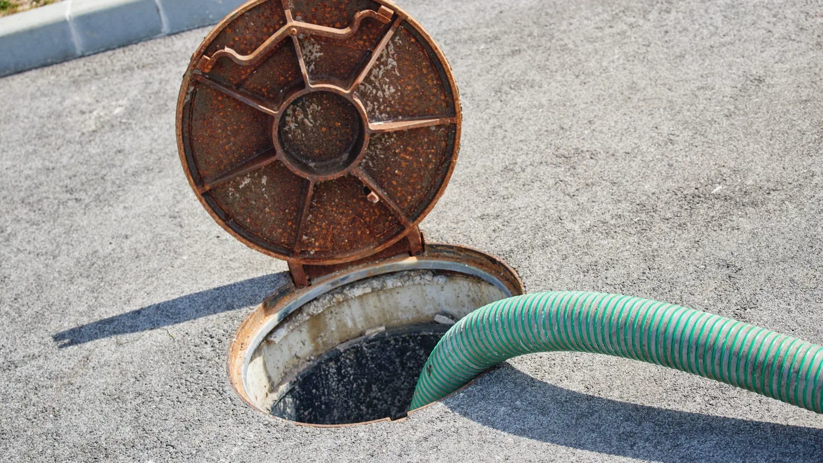 Technician opening septic lid for evaluation